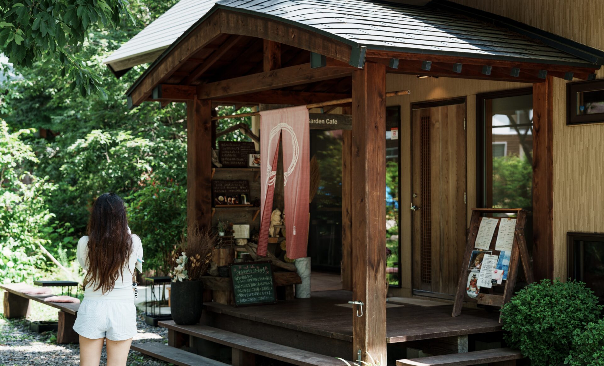 Wooden entrance of cozy café in Hakuba surrounded by greenery