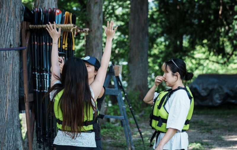 APC Base2 Staff instructing how to wear a life jacket before paddleboarding at Lake Aoki in Hakuba, Nagano.