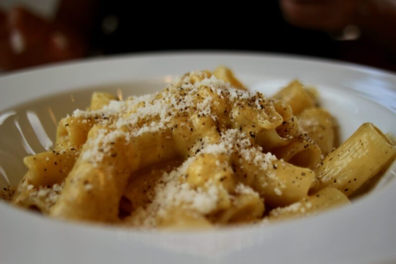 Close-up of gnocchi in rich tomato sauce topped with fresh parsley and grated cheese, served on an elegant white plate — authentic Italian pasta dish at a cozy Hakuba mountain café. Ask ChatGPT