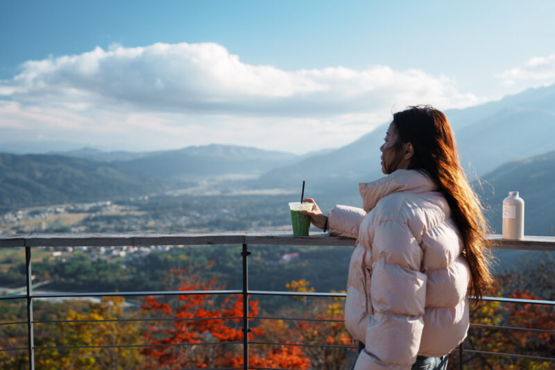 Girl looking out to Hakuba Valley from the outdoor terrace of CHAVATY HAKUBA.