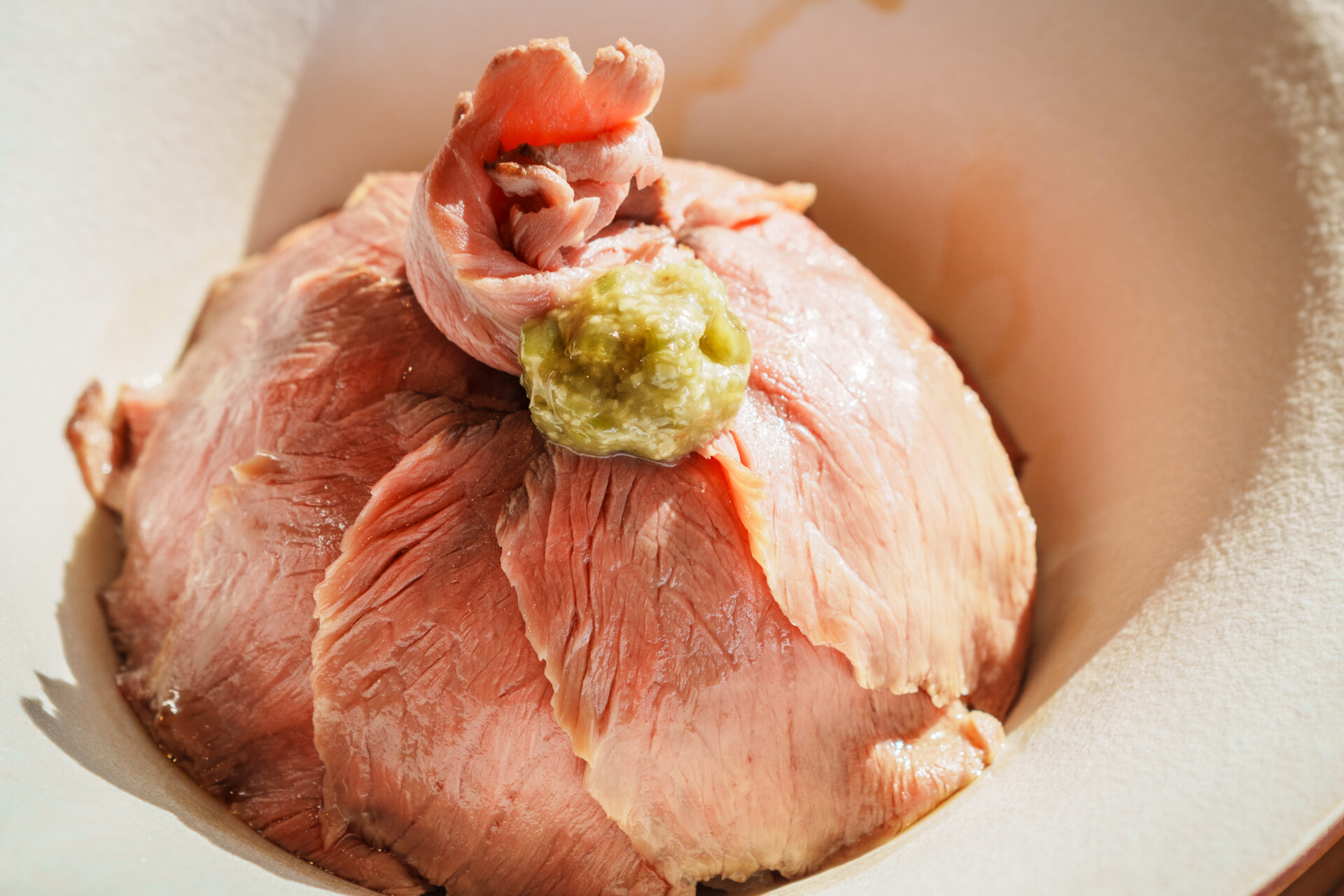 Hand holding a CHAVATY HAKUBA iced matcha latte with mountain views in the background — premium tea latte specialty café in the Japanese Alps, offering scenic outdoor experiences and artisanal drinks made with carefully selected tea leaves.