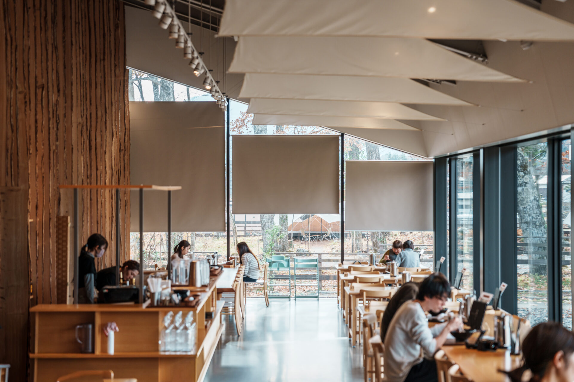 Modern triangular-roof interior of CHAVATY HAKUBA, a scenic tea latte café in the Japanese Alps, featuring floor-to-ceiling windows with panoramic mountain views and a stylish wood-beamed design — a must-visit spot for tea lovers and architecture enthusiasts in Hakuba.