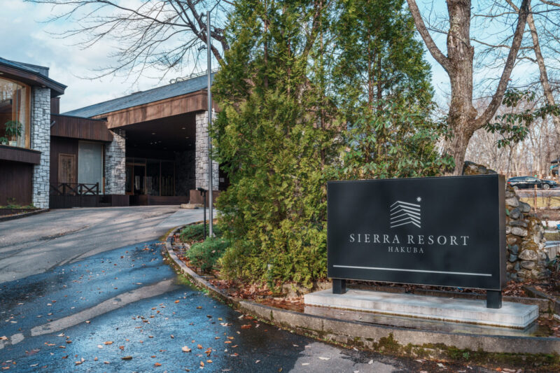 Bear Burger from Bears Café Kumaza in Hakuba, Japan, served with thick-cut potato wedges and topped with lettuce, tomato, onion, and sauce, labeled with a Japanese flag reading “bear” (熊).