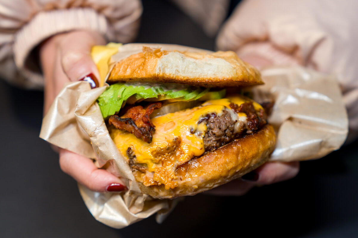 Close-up of hands shaping molten glass over a flame torch during a glass bead workshop at Kira Kira Glass in Nagano, Japan.